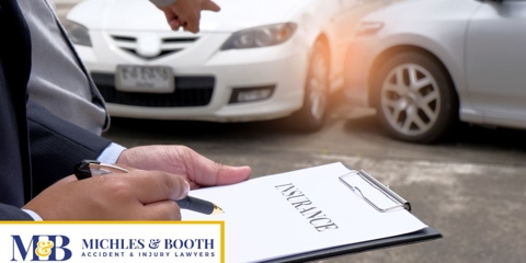 insurance adjuster and man looking at a car accident