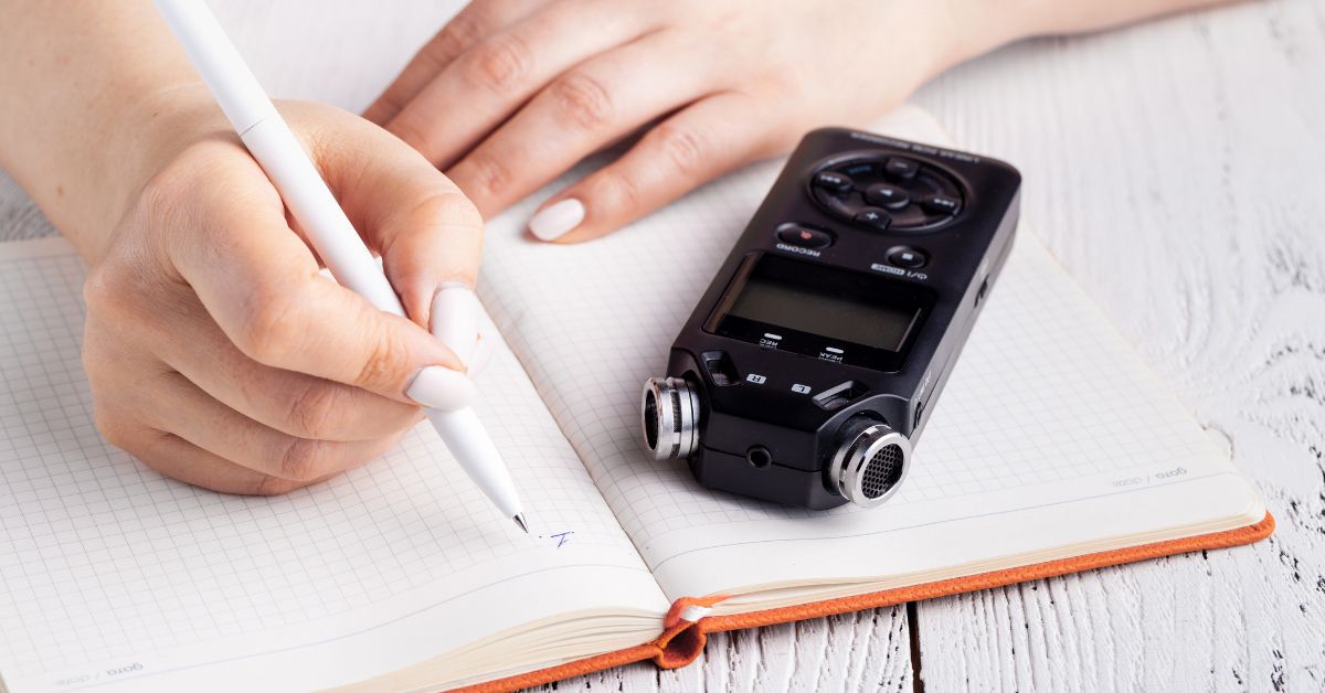 hands taking notes next to a recorder