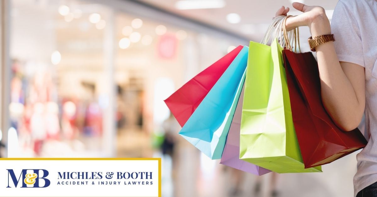 Woman holding a bunch of bright colored shopping bags.