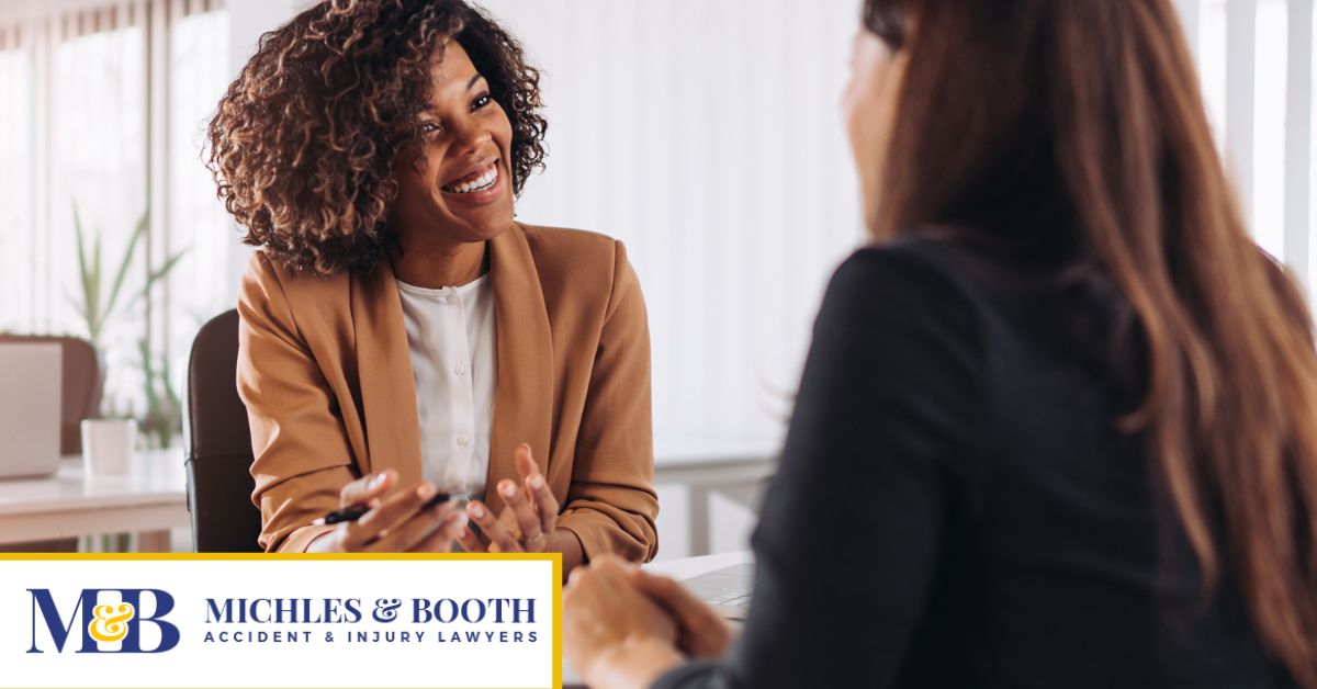 Woman holding pen while speaking to another woman