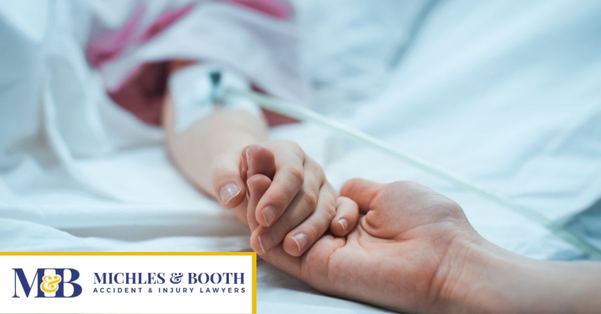 Person holding hands with another person who has an IV in their arm