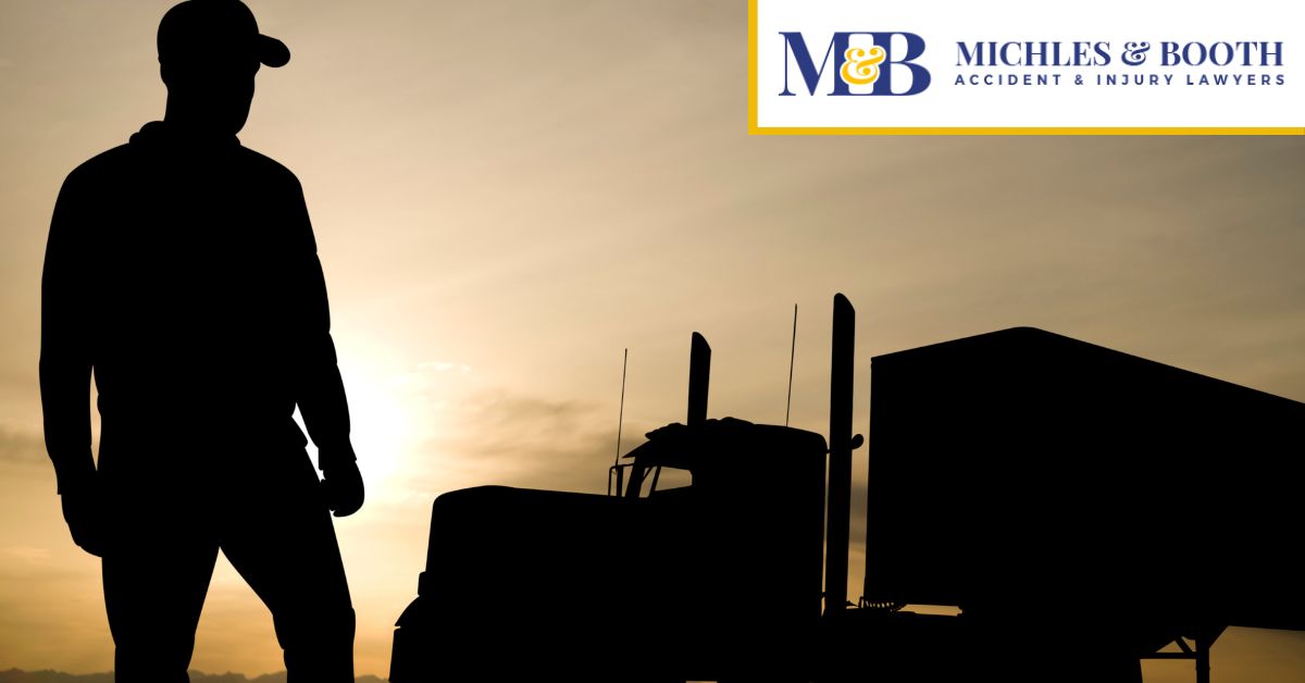 Silhouette of a man standing in front of an 18-wheeler