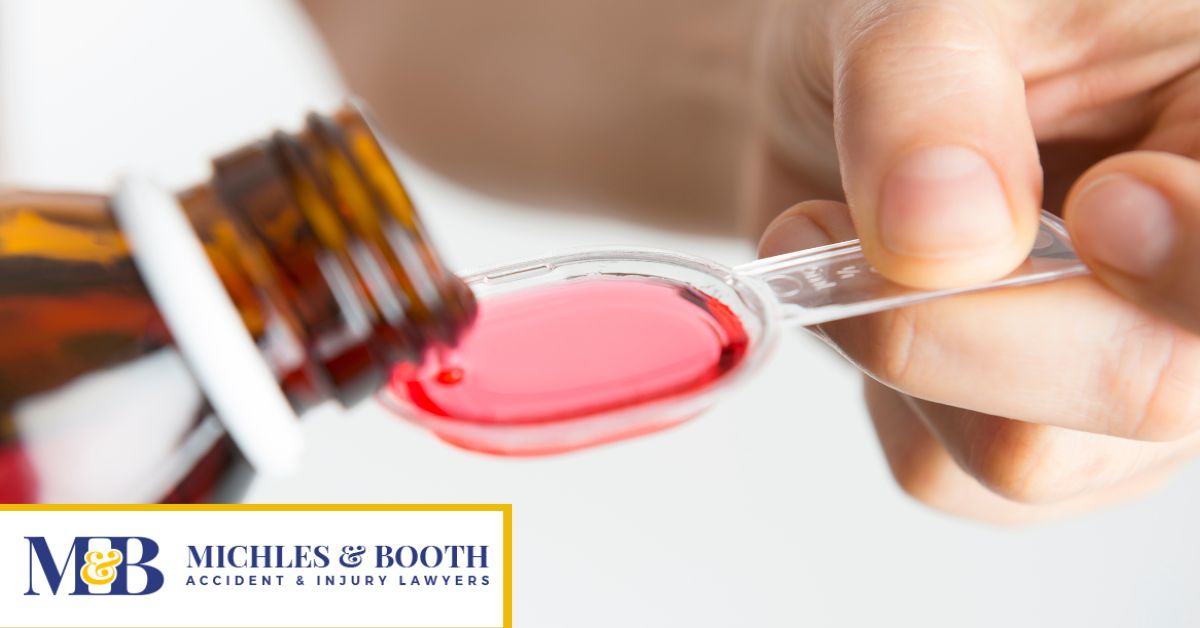 Prescription syrup being poured into a teaspoon.