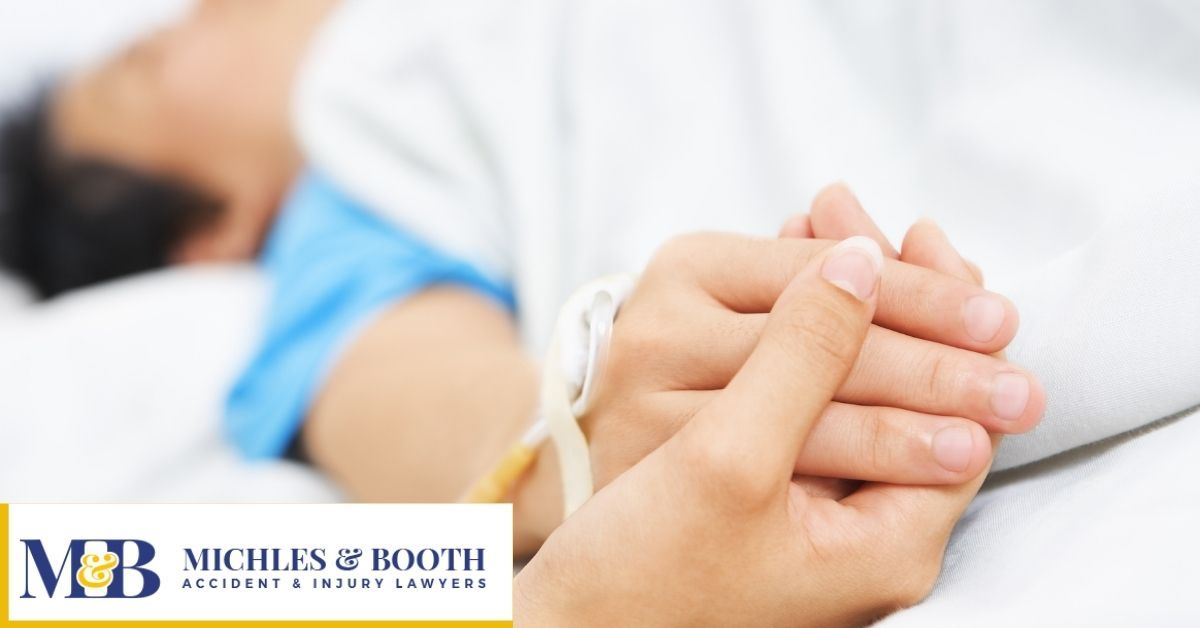 People holding hands on a hospital bed
